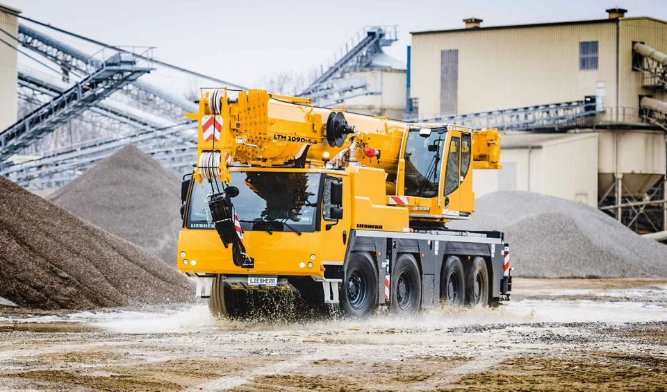 Liebherr LTM 1090-4.2 OEM travel image showing the four-axle carrier and stowed boom.